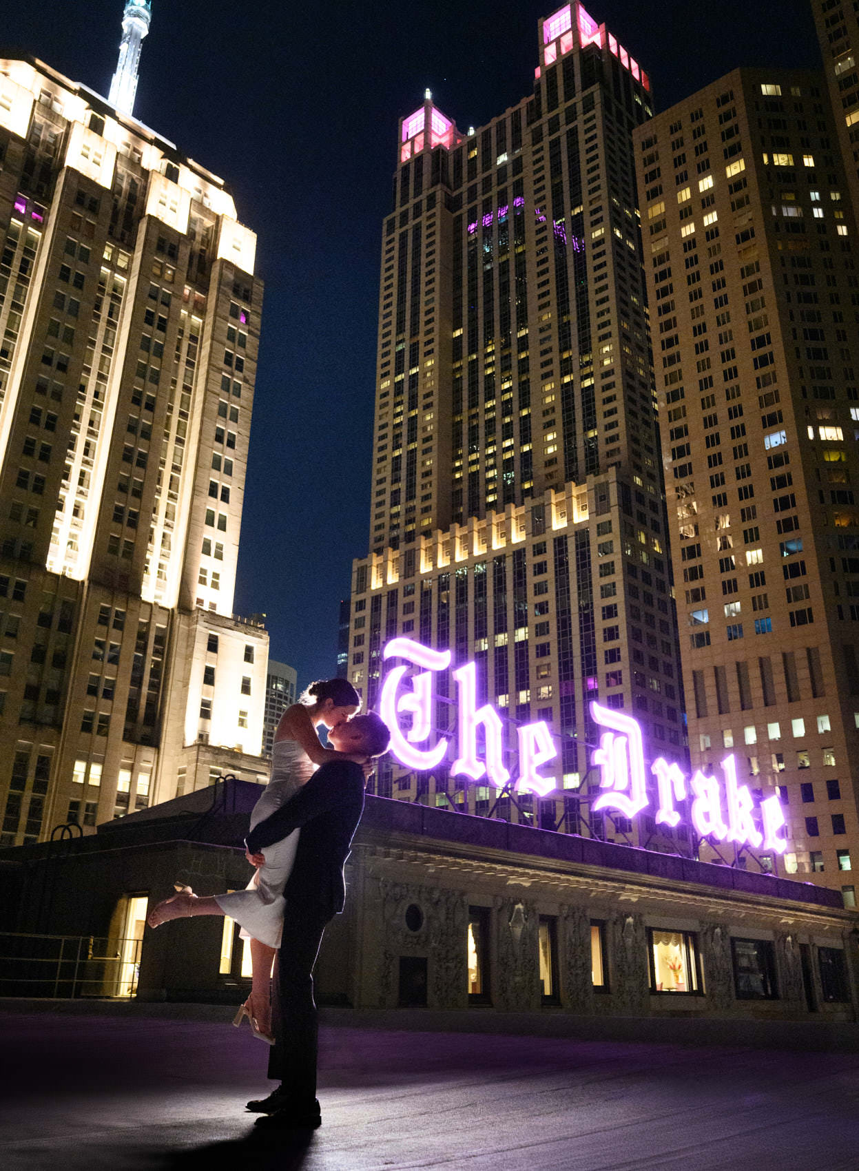 bride and groom kiss at night on rooftop of drake hotel