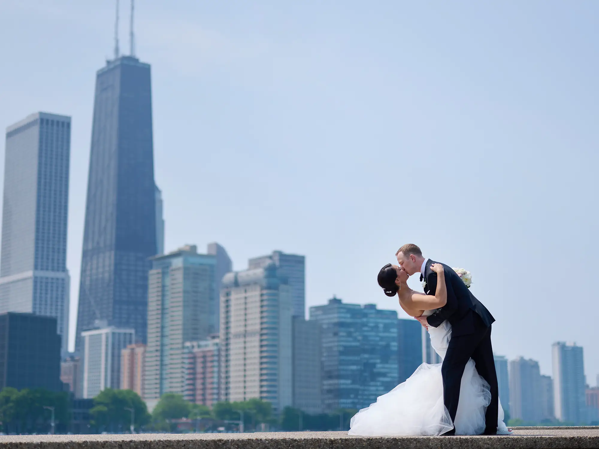 chicago wedding couple in front of chicago skyline with a dip and kiss