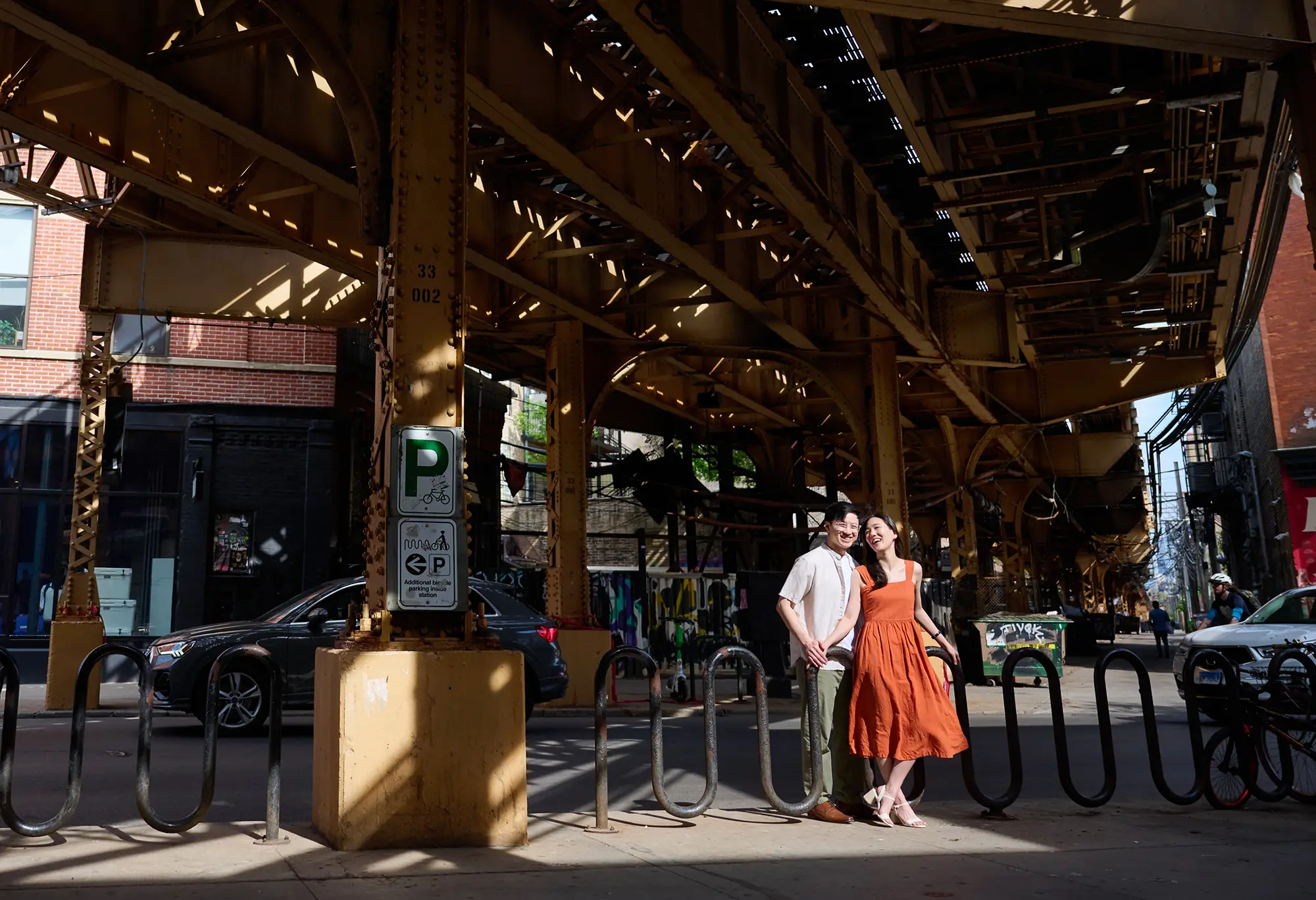 couple standing under CTA train tracks