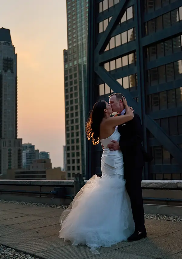 ritz carlton rooftop bride and groom kiss at sunset