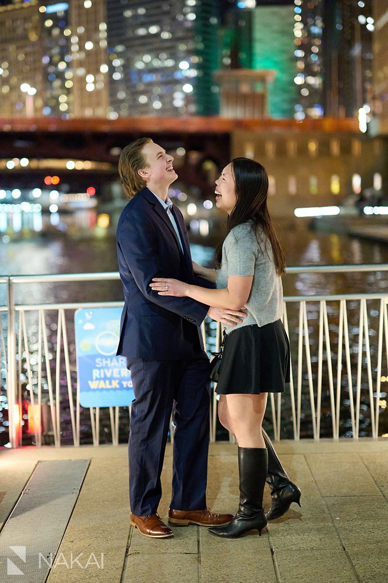 surprise proposal chicago photos on riverwalk at night. Couple laughing together