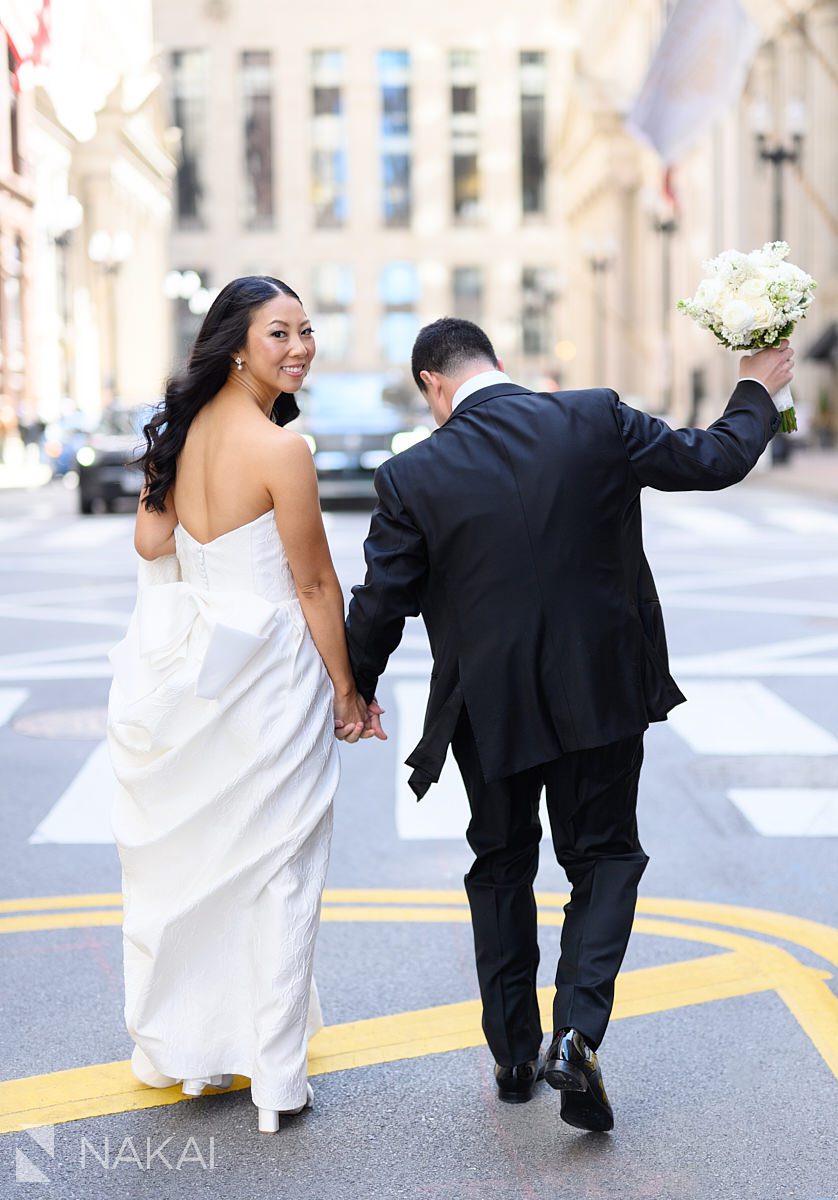 bride and groom walking LaSalle St chicago wedding pictures 
