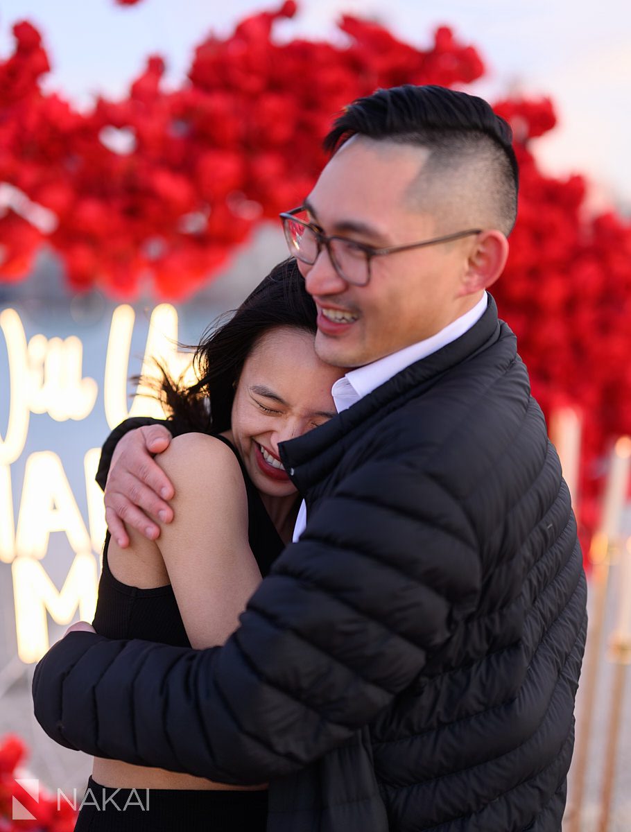 rose heart wreath backdrop on North Avenue Beach. Engagement proposal ideas Chicago with skyline 