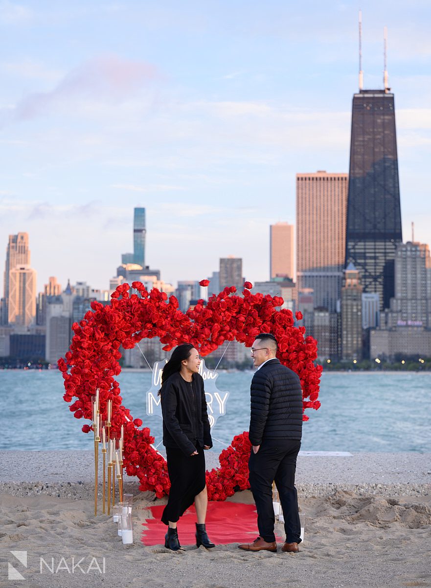 rose heart wreath backdrop on North Ave Beach. Engagement proposal ideas Chicago with skyline 