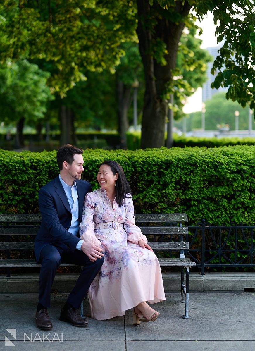 romantic museum campus engagement pictures sitting on bench laughing at each other