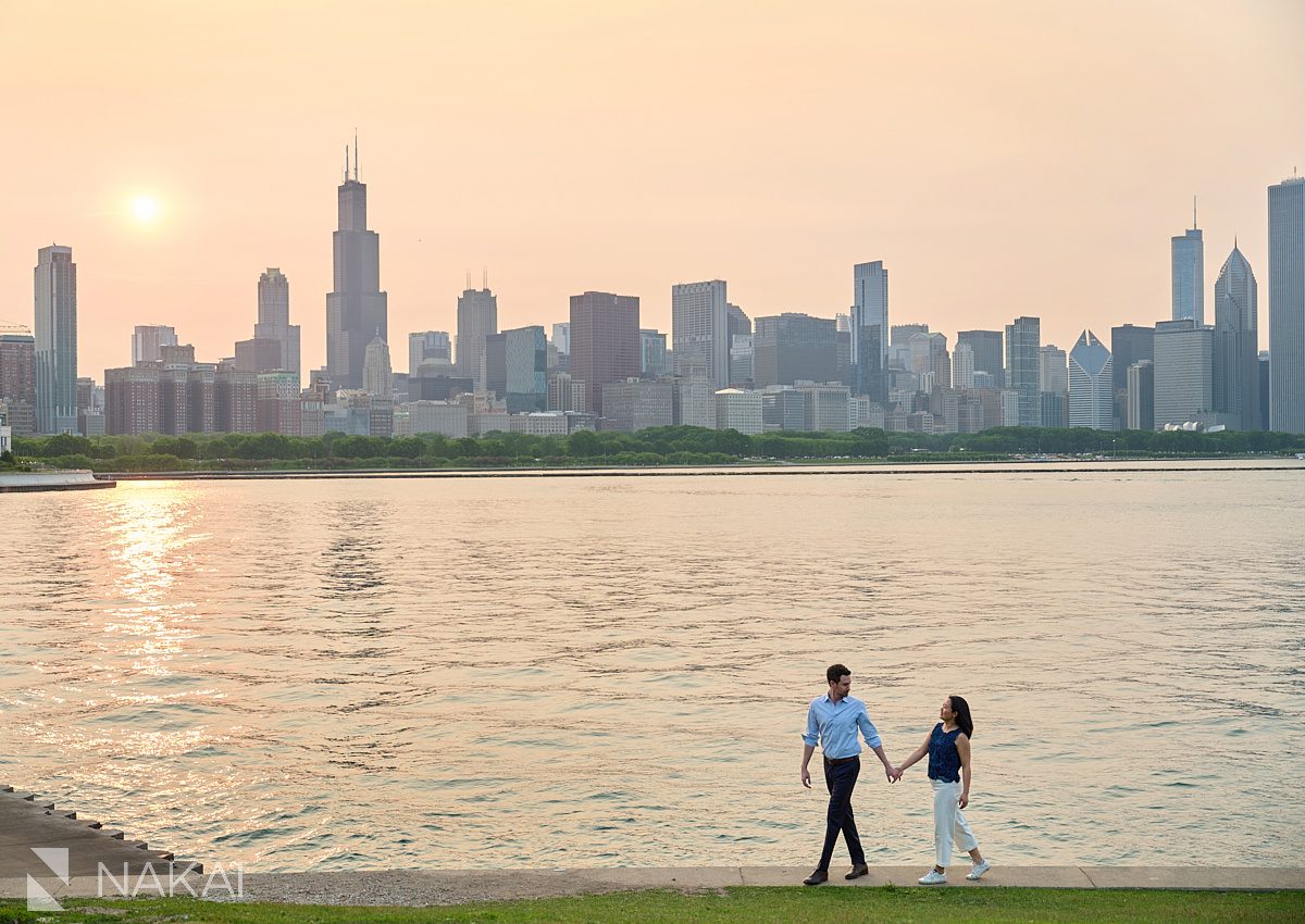 romantic museum campus engagement pictures walking with lake and skyline in background. Setting sun