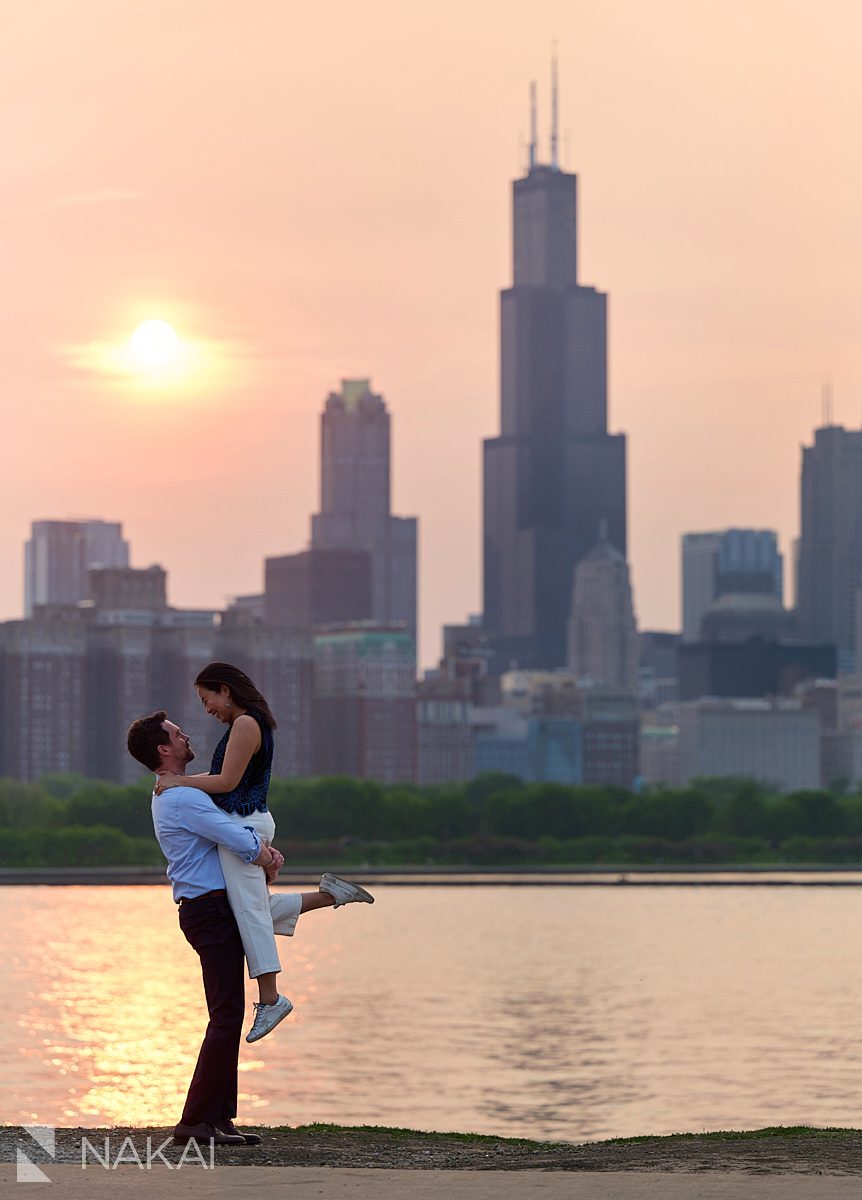 museum campus engagement skyline photos setting sun orange haze sky picking her up in the air