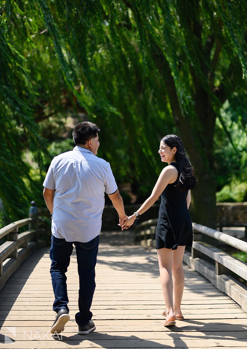 holding hands on Japanese garden bridge for Chicago botanic gardens proposal photos