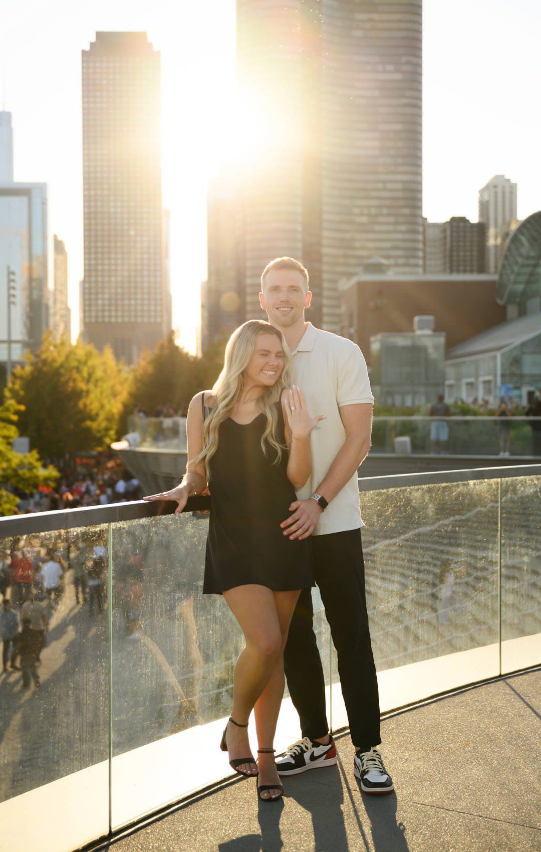 surprise chicago navy pier proposal photos showing off ring with sunflare in background