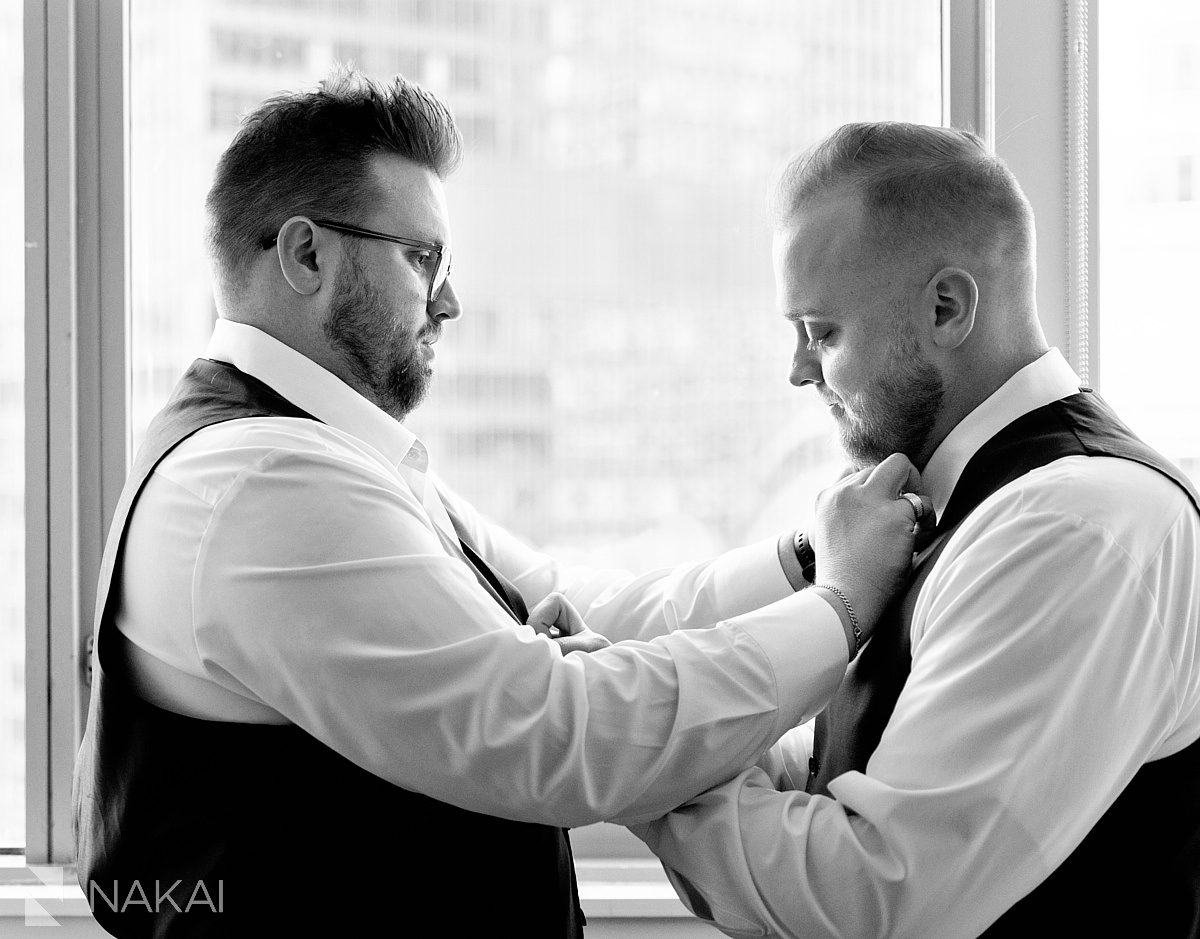 groom getting ready chicago wedding putting tie on