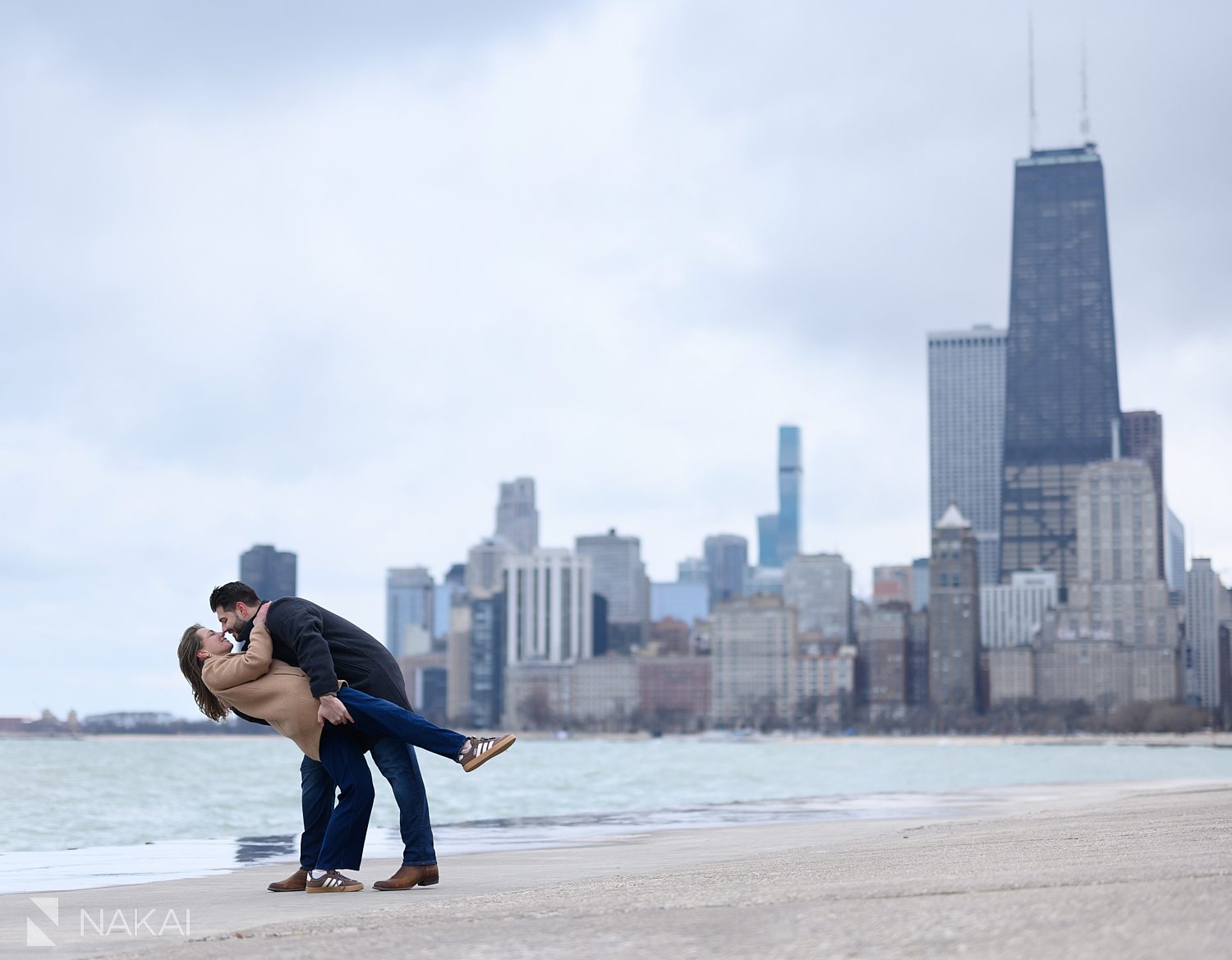 couple dipping during engagement photo at North ave beach