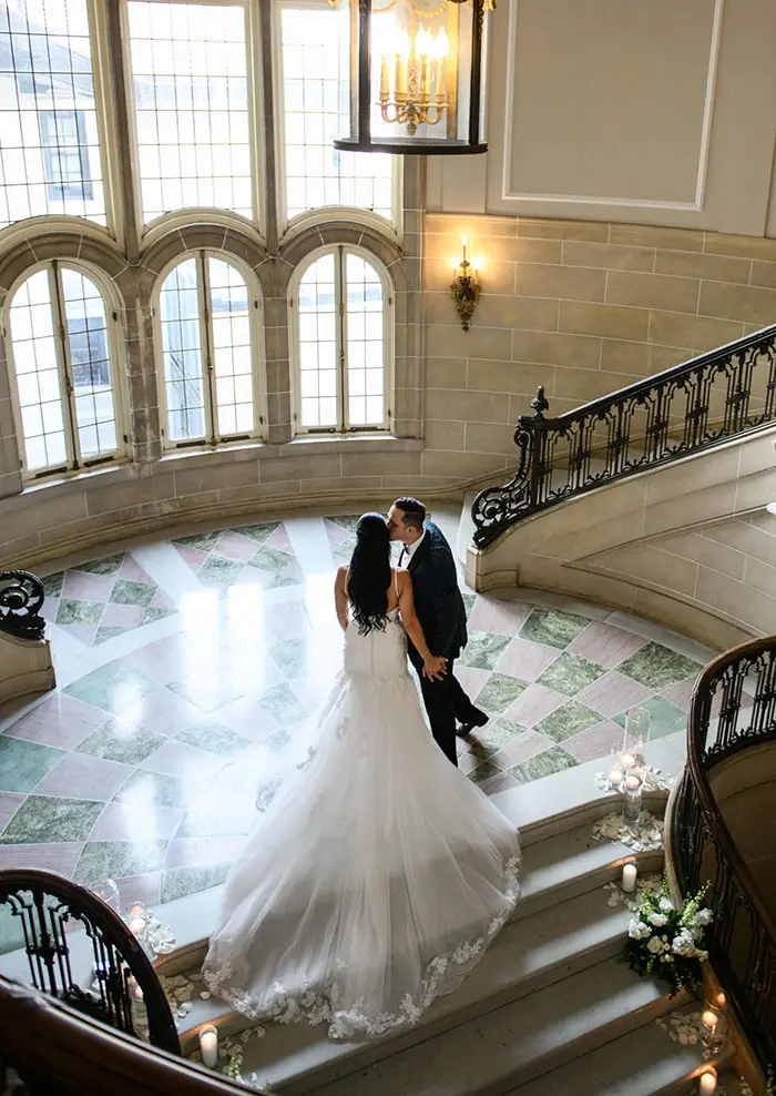 armour house wedding photo on staircase kissing bride