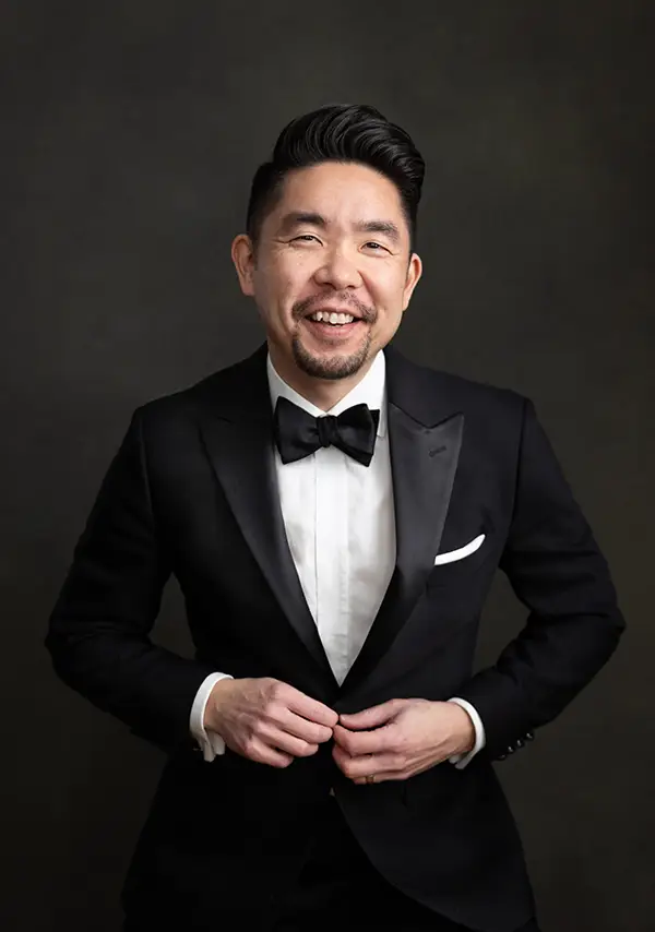 kenny nakai chicago photographer in tuxedo on dark backdrop