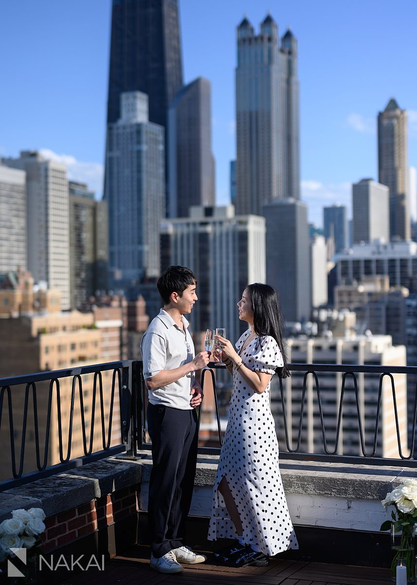 ambassador chicago proposal skyline in background drinking champagne