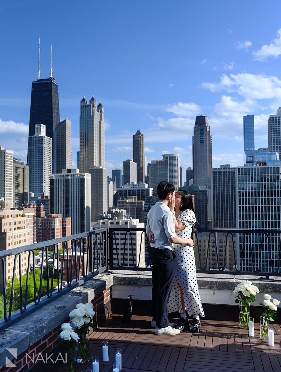 kiss after chicago private proposal rootop with skyline in background