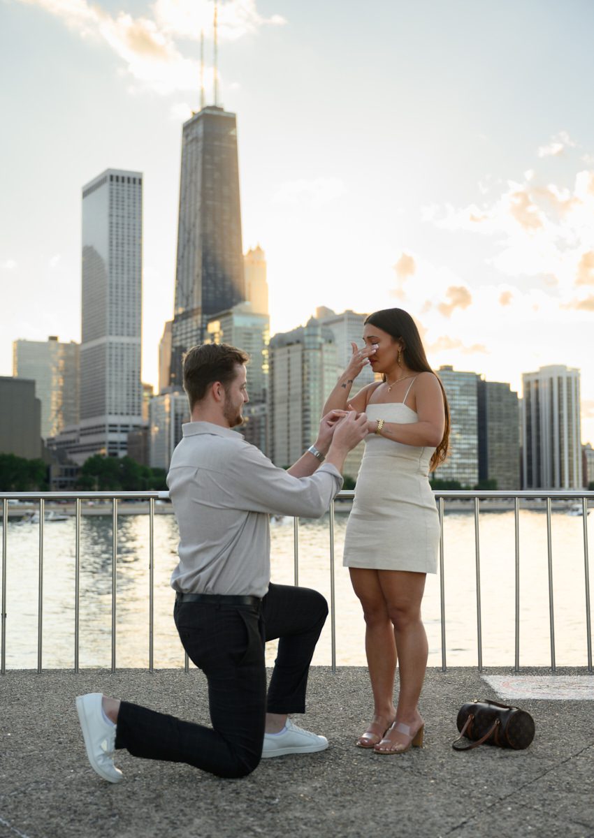 putting ring on at fake out suprise proposal chicago at olive park