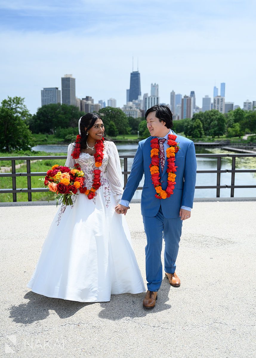 chicago south pond wedding photo multicultural couple walking on bridge