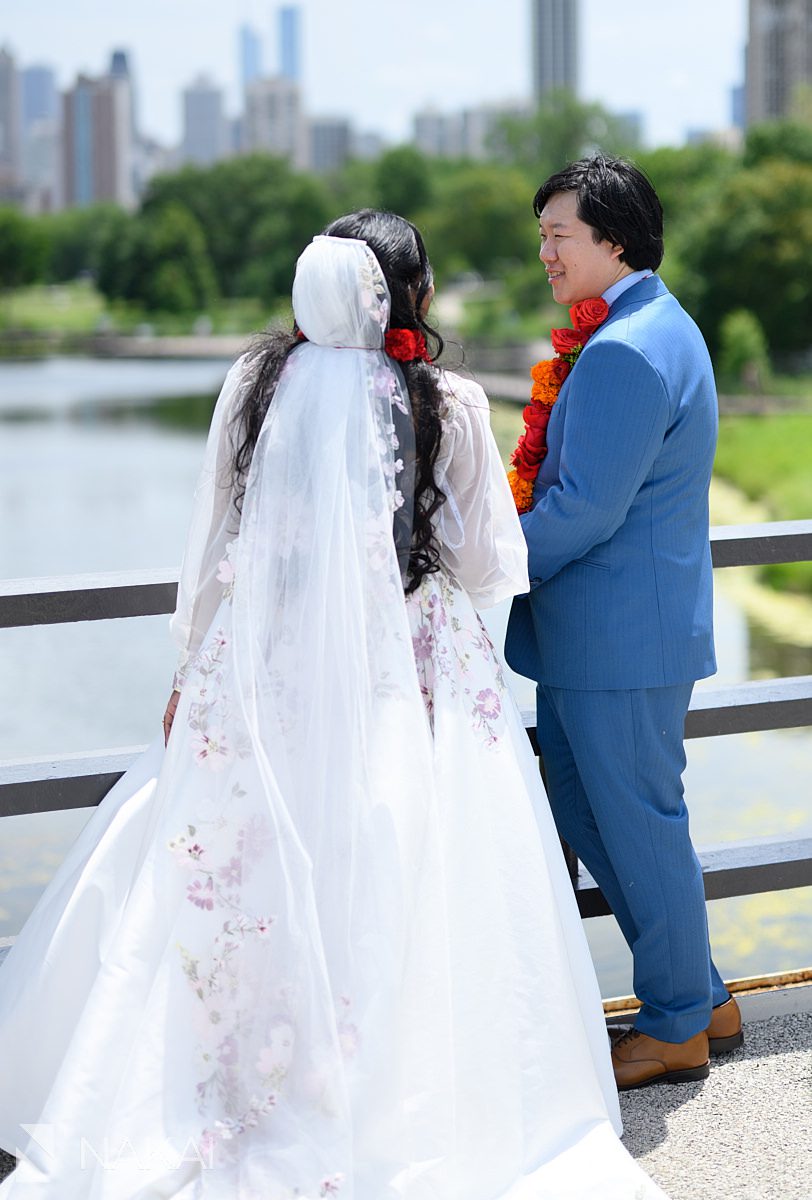 couple standing on bridge over south pond looking at each other
