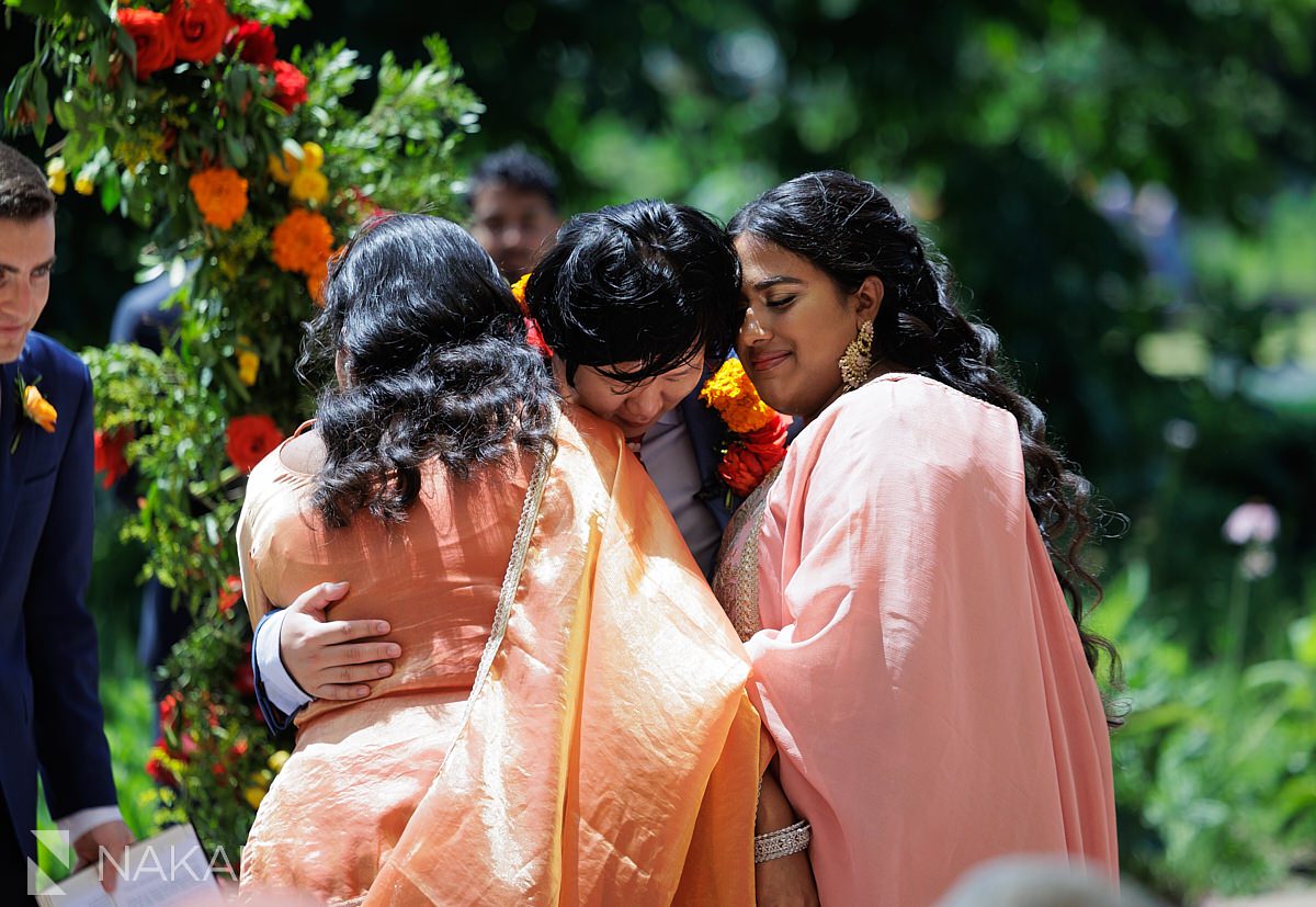 putting flower garland on groom