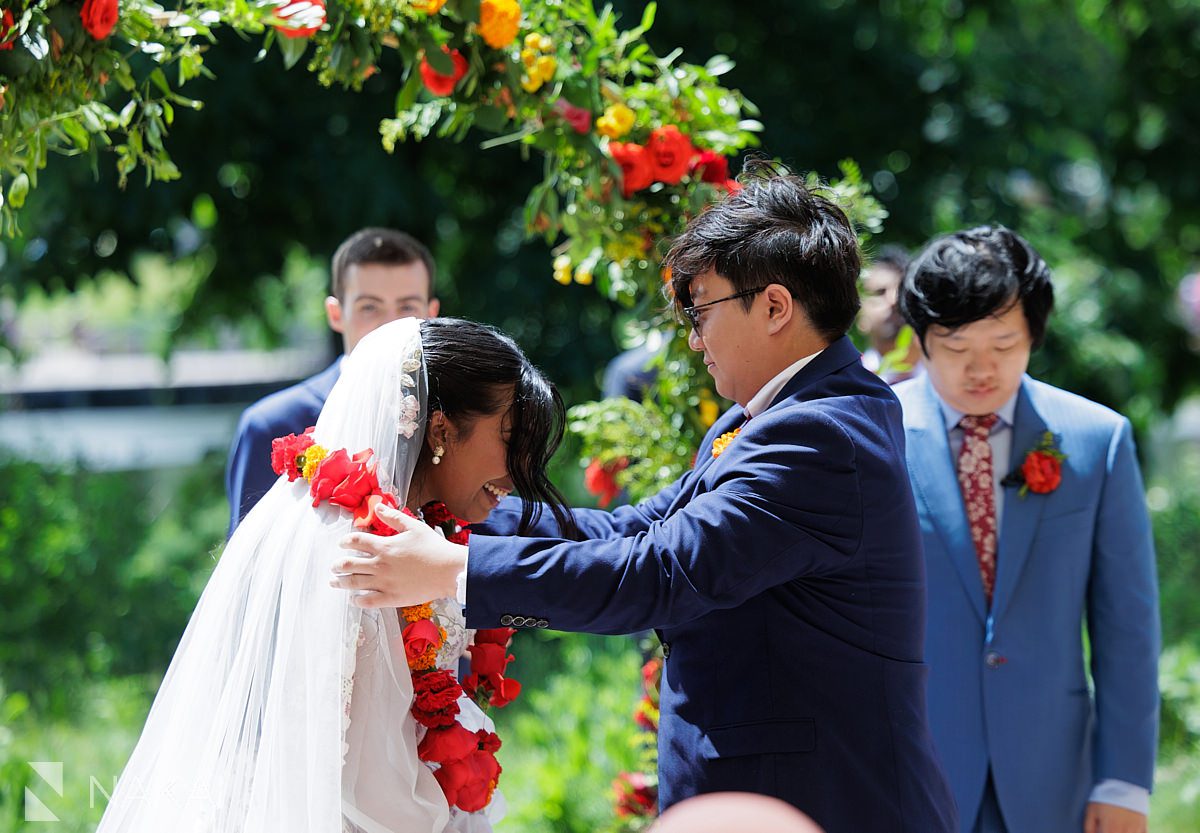 putting flower garland on bride