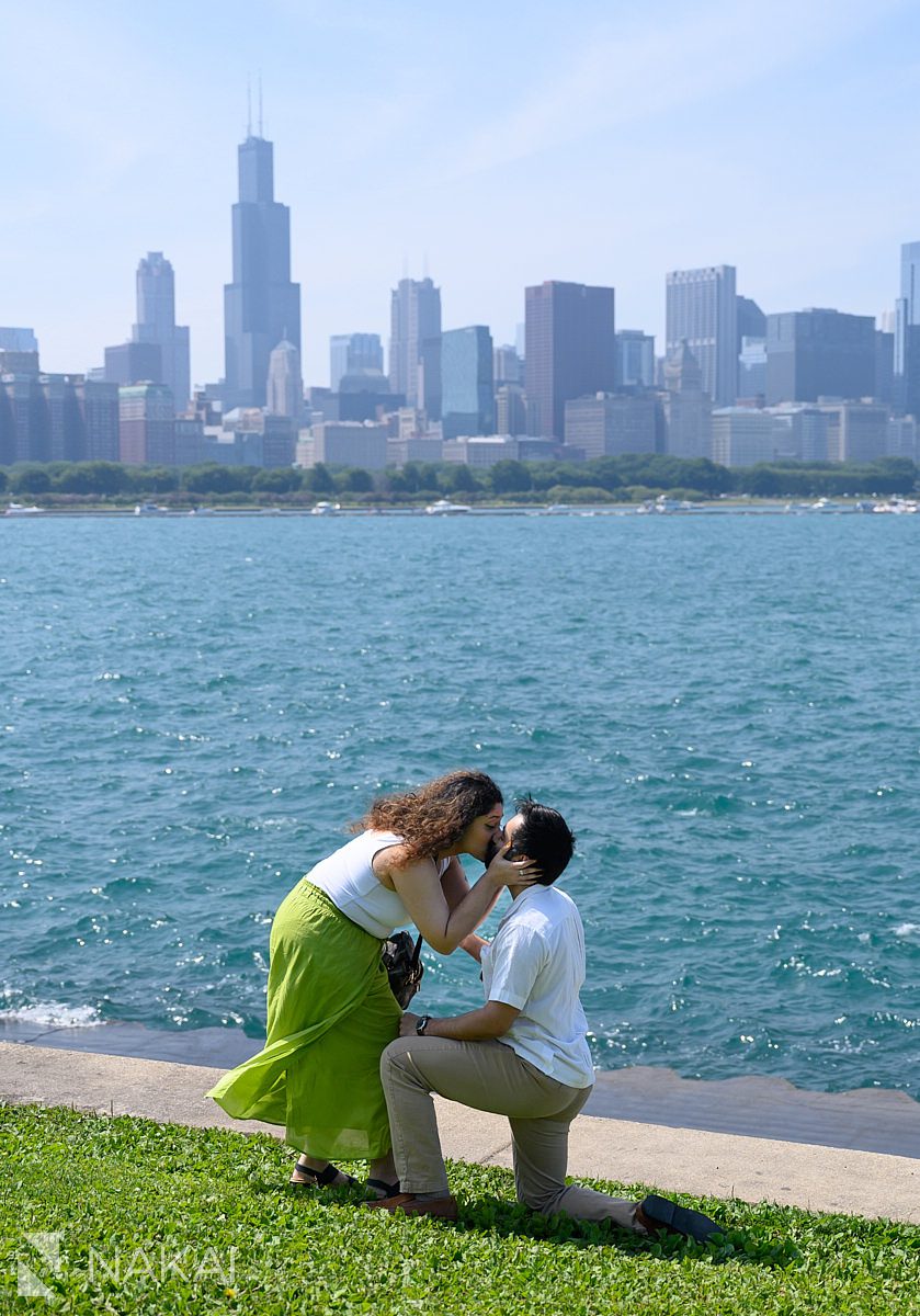 adler planetarium proposal, kissing the guy on bended knee, skyline in background, sunny day