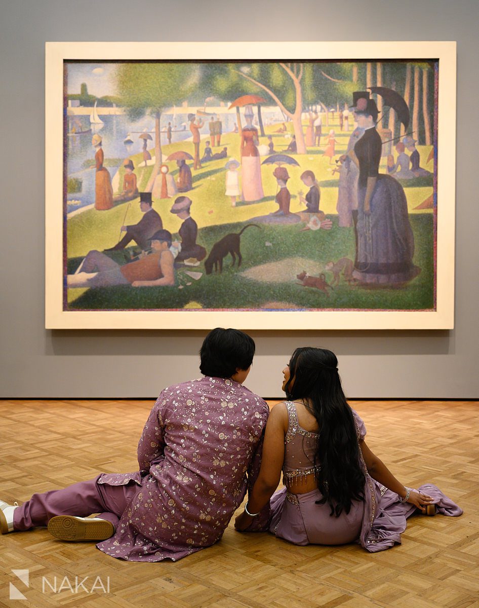 sitting in front Suerat's la grande jatte engagement photo