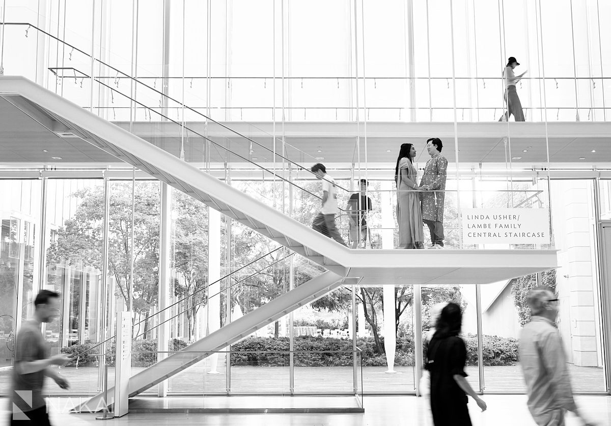 couple on modern wing staircase in art institute engagement indoor photo