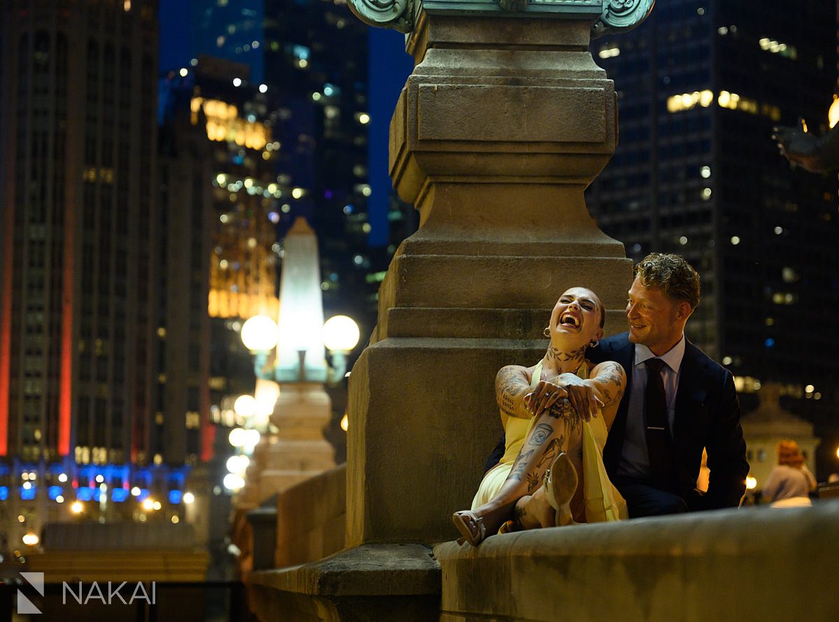 sitting laughing at chicago night time riverwalk engagement 