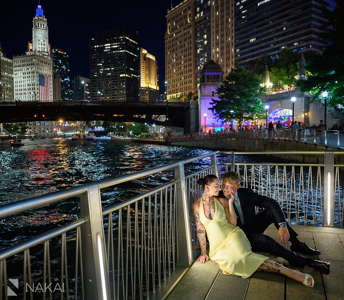 sitting and cuddling chicago night time riverwalk engagement 