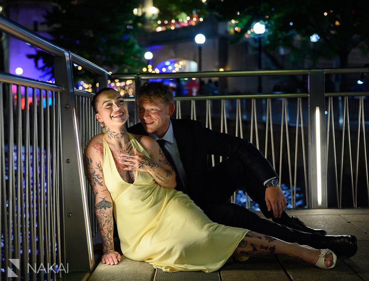 laughing while sitting chicago riverwalk engagement night time