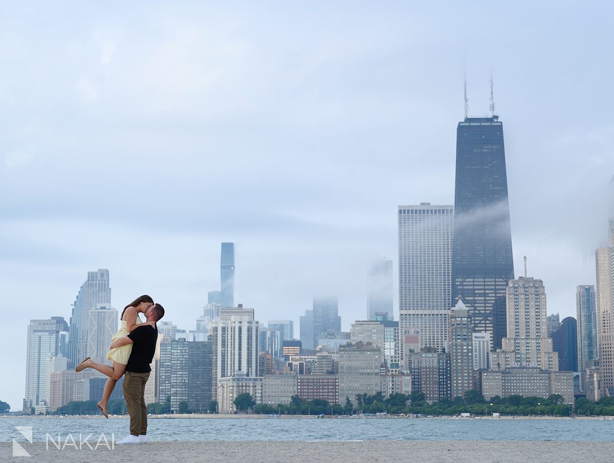 lift kiss at north ave beach during chicago skyline engagement