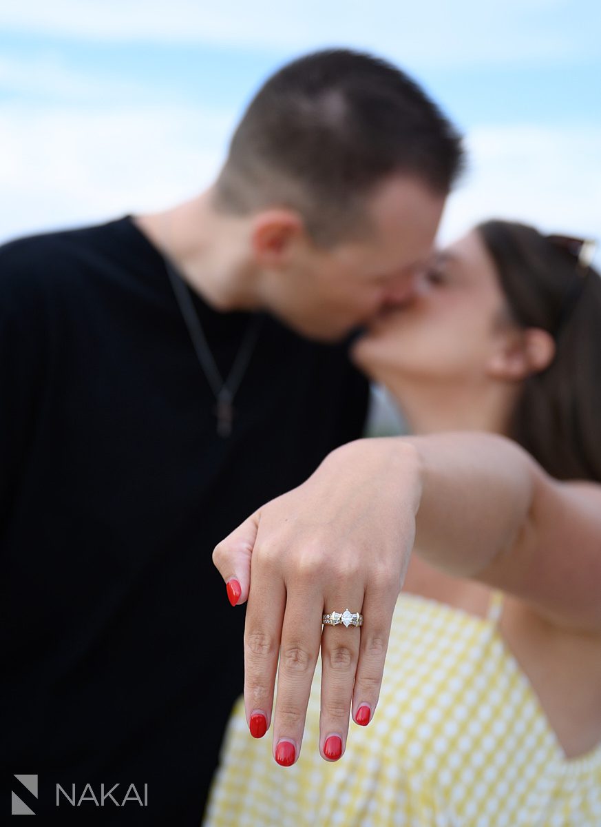 ring in foreground, kiss in background after peoples gas pavilion proposal