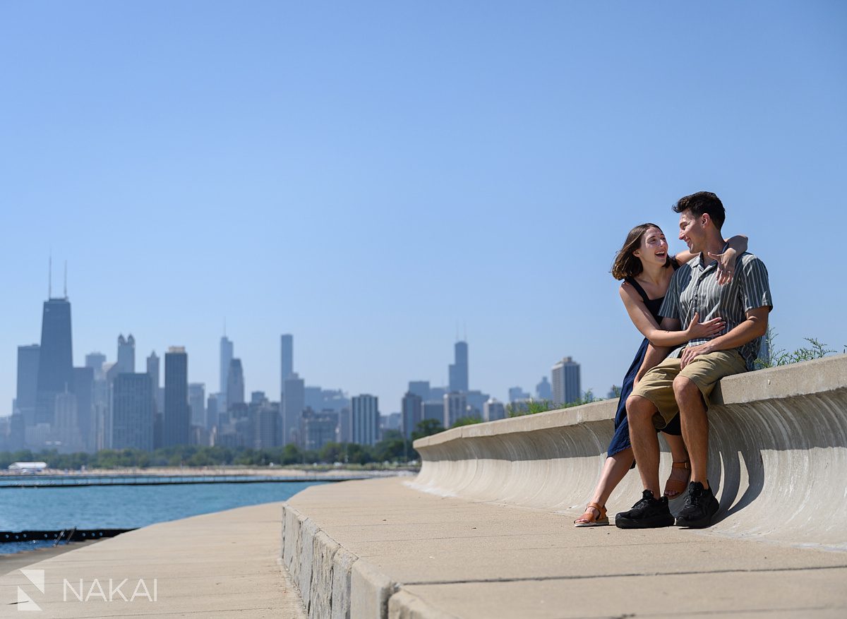 sitting laughing chicago water engagement skyline in background