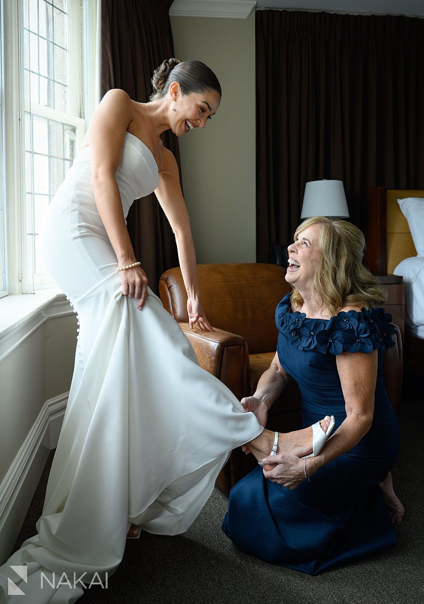 mom putting on brides shoes university club chicago wedding photo