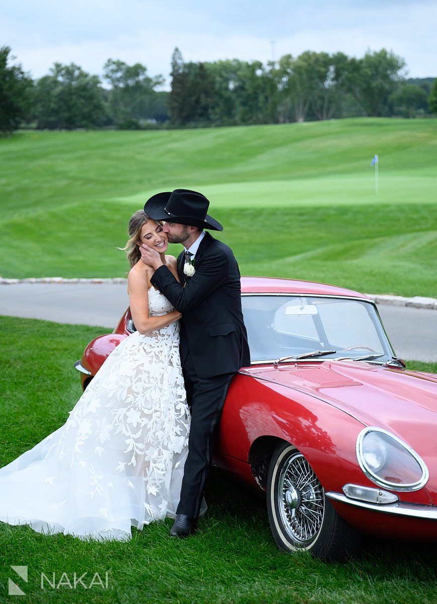 red vintage sports car bride groom kiss