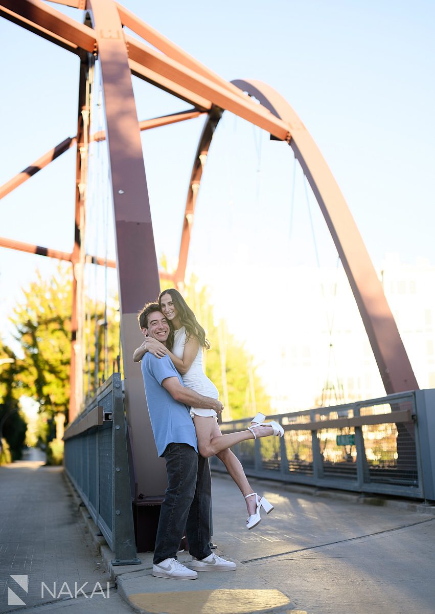 606 Bloomingdale Trail engagement photos couple on bridge, lifting and laughing