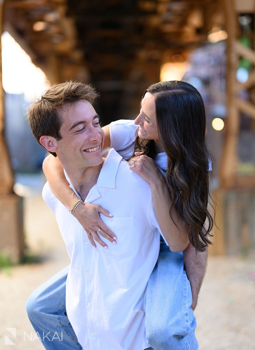 chicago neighborhood engagement photos under CTA tracks couple piggyback ride