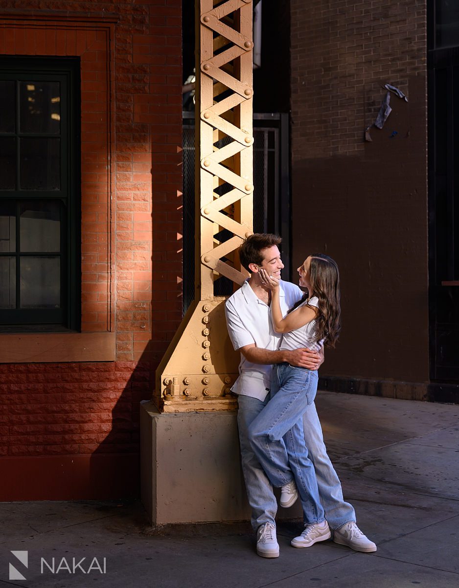 wicker park engagement photos couple holding each other under CTA tracks