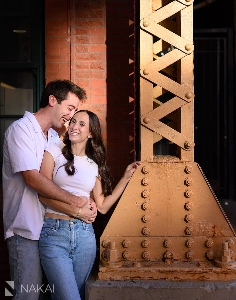 wicker park engagement photos couple laughing under CTA tracks